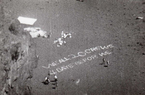 L'équipage écrit dans le sable pour le Neptune de la 16S, qui les recherche